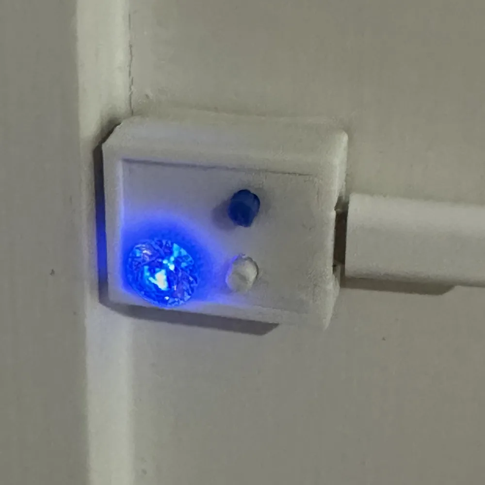 BusyBeacon presence indicator mounted on a door frame, glowing blue