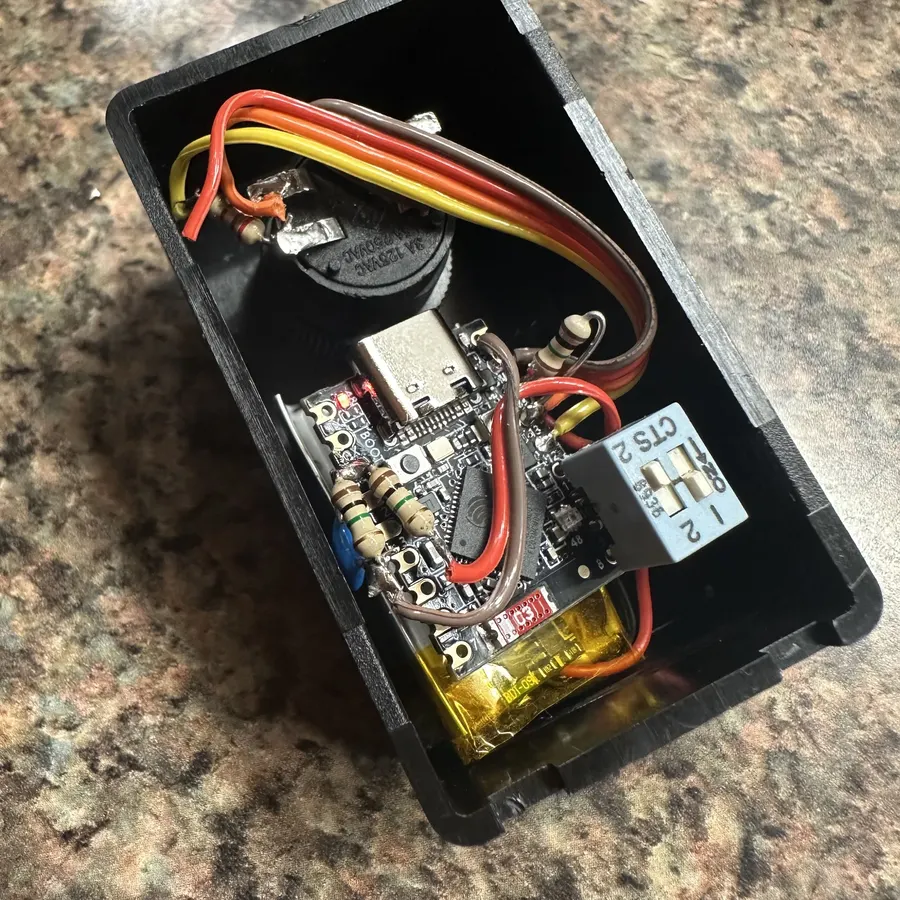 Inside of the Stamper button: ESP32-S3 board, LiPo cell, and illuminated pushbutton in a 3D-printed enclosure